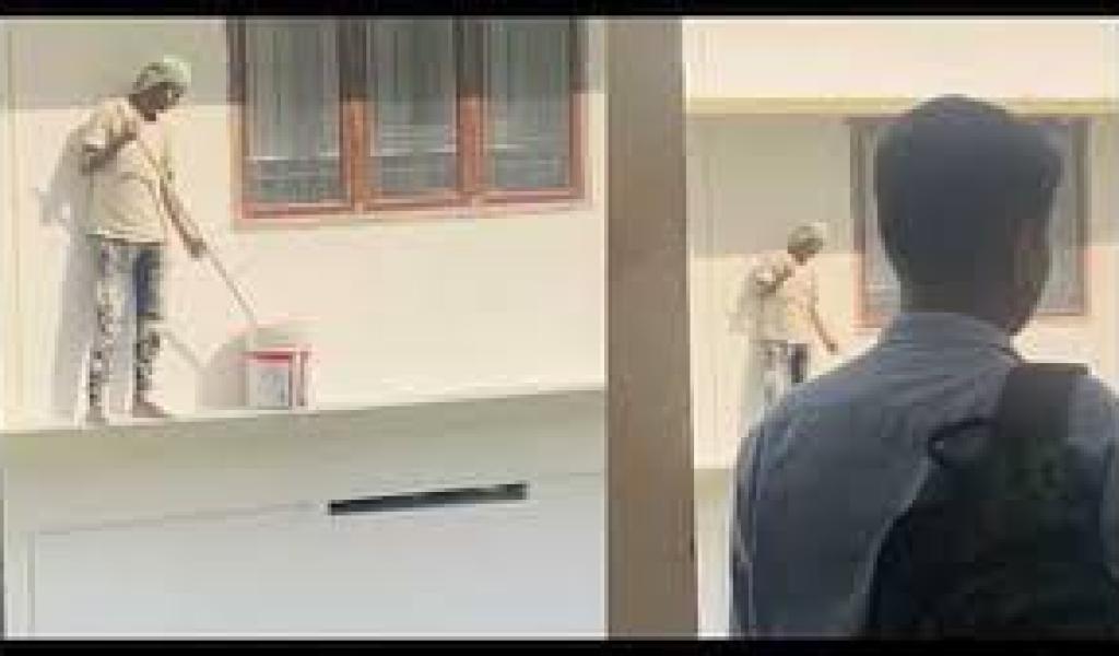 एक कॉलेज की इमारत पेंट कर रहा मज़दूर राष्ट्रगान